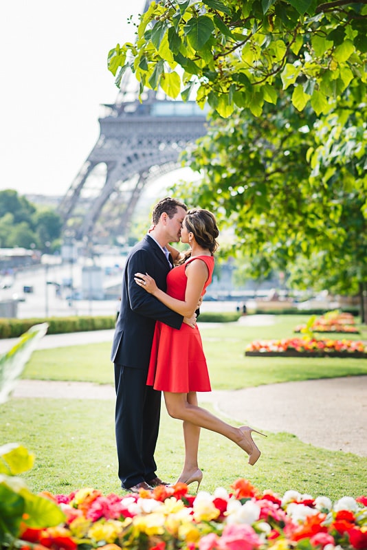 Lady in red kissing her husband surrounded by flowers Lady in red kissing her husband surrounded by flowers