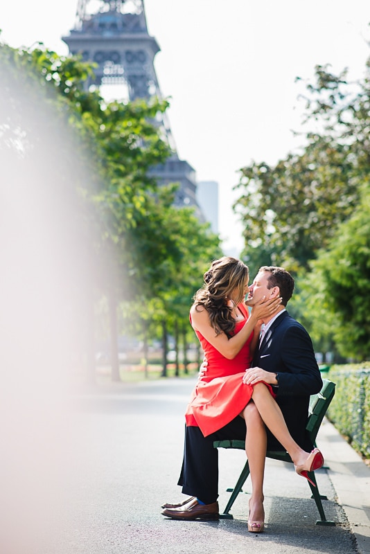 Couple kissing on a bench in front of the Eiffel Tower Couple kissing on a bench in front of the Eiffel Tower