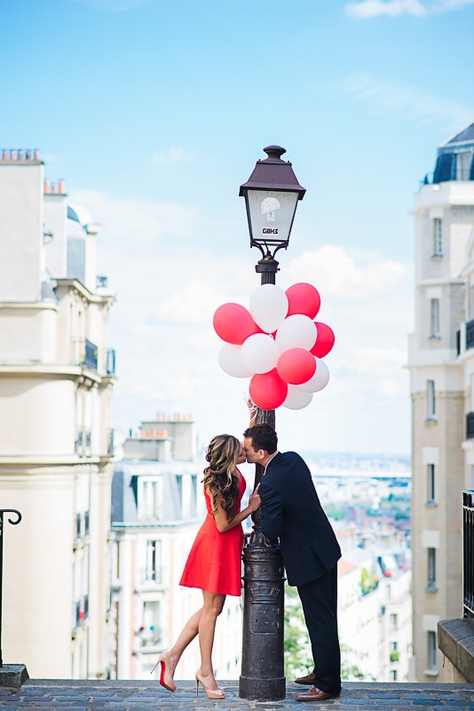 Couple kissing under red balloons in Montmarte Couple kissing under red balloons in Montmarte