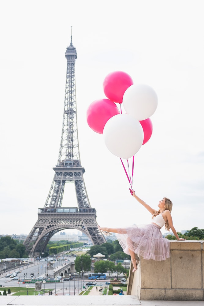 Pretty girl wearing pink tutu dress holding pink balloons at the Eiffel Tower Pretty girl wearing pink tutu dress holding pink balloons at the Eiffel Tower