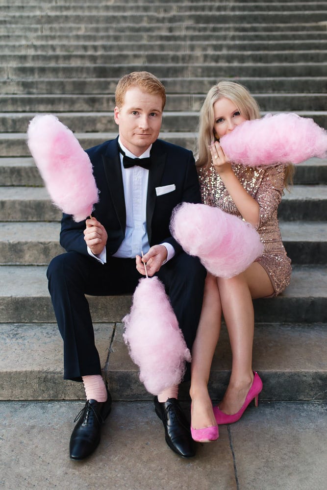 Stylish couple posing for engagement photos with pink cotton candy Stylish couple posing for engagement photos with pink cotton candy