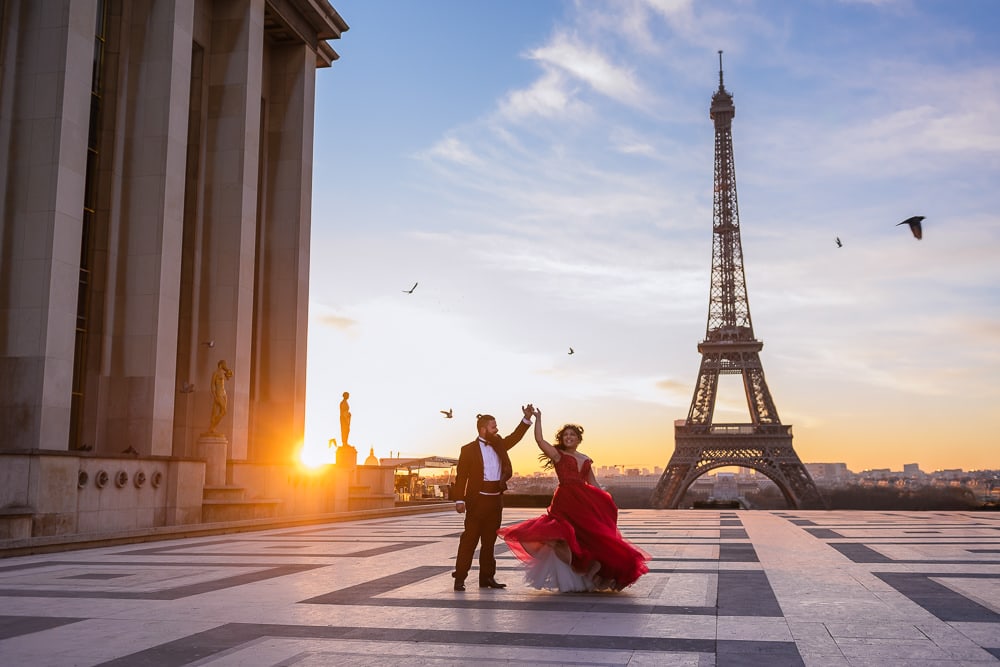 paris prewedding photographer capturing bride in red dress dancing at sunrise in front of the eiffel tower paris prewedding photographer capturing bride in red dress dancing at sunrise in front of the eiffel tower