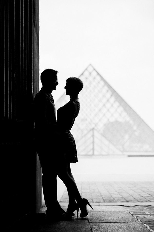 Silhouette picture Louvre Pyramid with couple after proposing in Paris