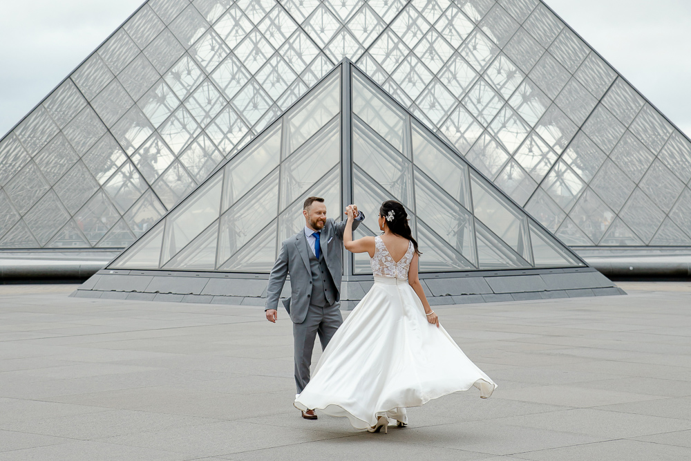 Bride dancing at Louvre Museum during wedding photo shoot with Lena